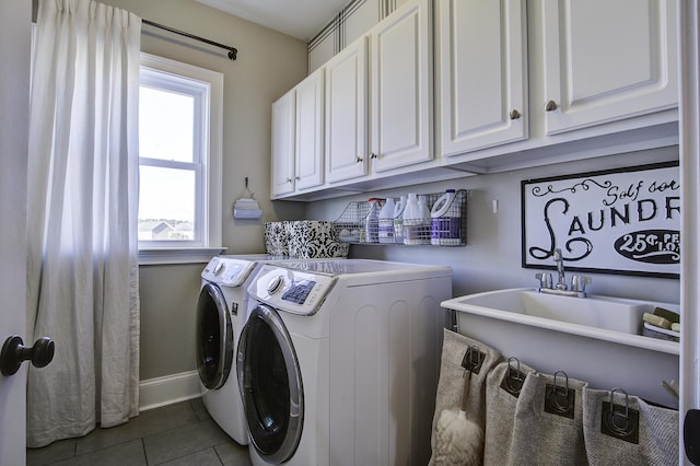 washroom with cabinets, washer and clothes dryer, and dark tile patterned flooring