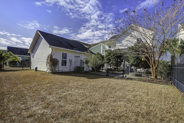 rear view of house with a patio and a lawn