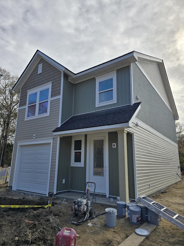 view of front of property featuring a garage and a shingled roof