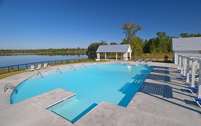 view of pool with a water view and a patio