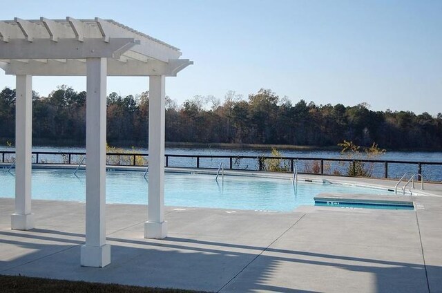 view of pool with a patio area, a pergola, and a water view