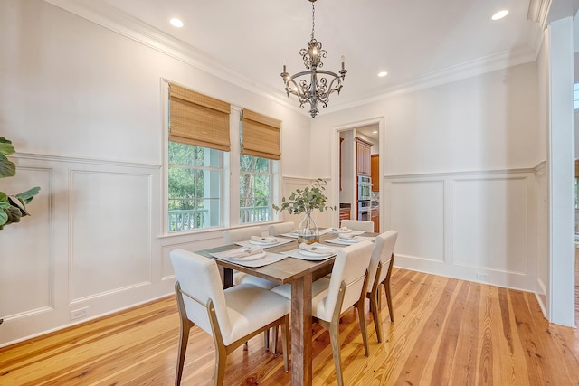 2701 Fountainhead Way, Mount Pleasant, SC 29466 - dining room featuring a decorative wall, a chandelier, wainscoting, light wood-style flooring, and ornamental molding