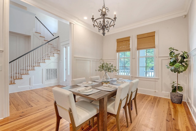 2701 Fountainhead Way, Mount Pleasant, SC 29466 - dining space with a decorative wall, stairs, a chandelier, ornamental molding, and light wood-style flooring