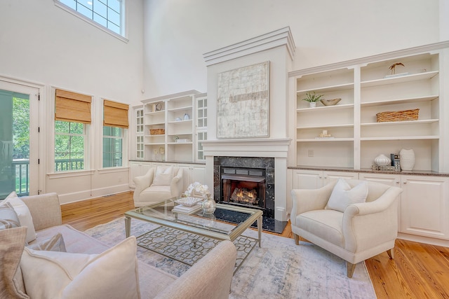 2701 Fountainhead Way, Mount Pleasant, SC 29466 - living area featuring light wood-style floors, a fireplace, a high ceiling, built in features, and baseboards