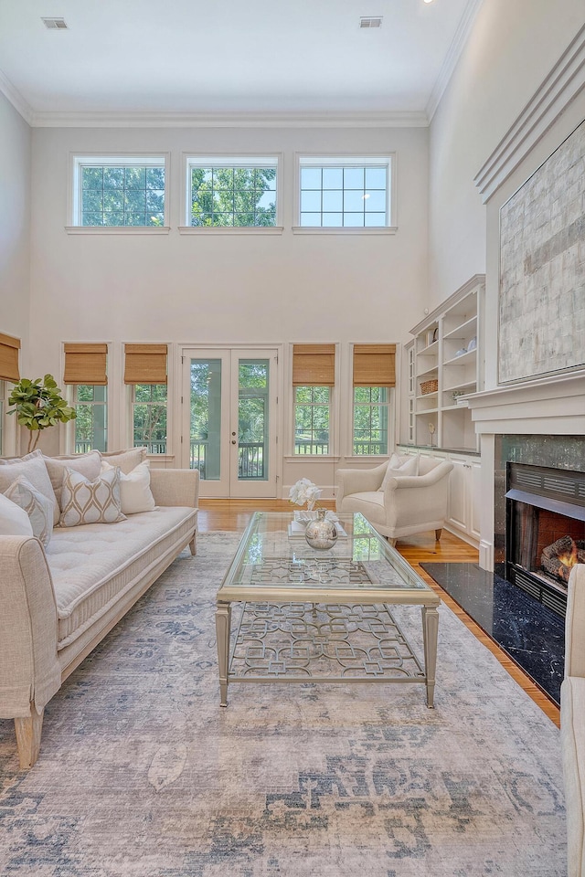 2701 Fountainhead Way, Mount Pleasant, SC 29466 - living area featuring a high ceiling, ornamental molding, wood finished floors, a premium fireplace, and french doors