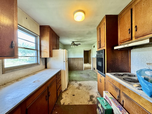 524 Kell Pl, Charleston, SC 29412 - kitchen featuring black oven, freestanding refrigerator, under cabinet range hood, brown cabinetry, and ceiling fan