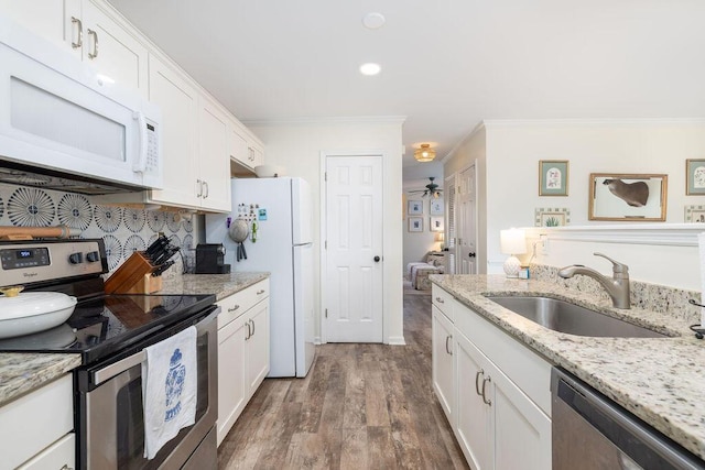 kitchen with ornamental molding, appliances with stainless steel finishes, a sink, and white cabinets