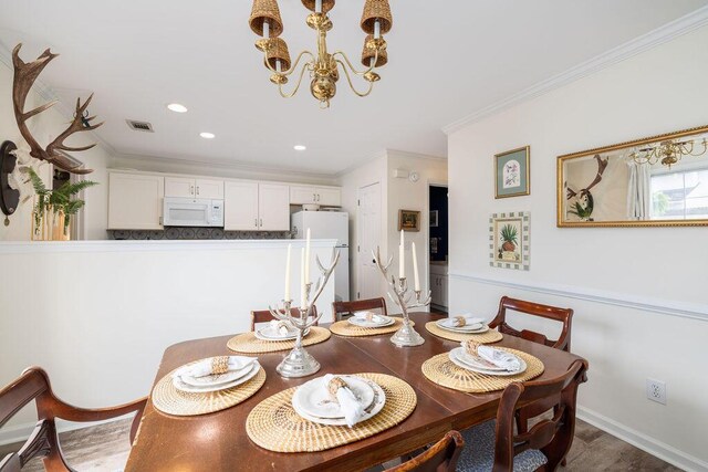 dining room with recessed lighting, visible vents, ornamental molding, dark wood finished floors, and an inviting chandelier