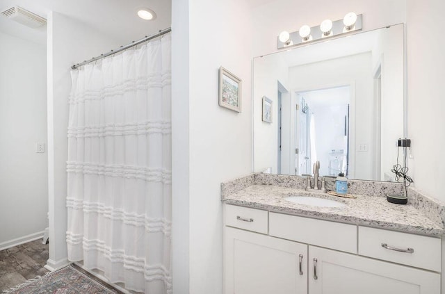 full bath featuring curtained shower, wood finished floors, vanity, visible vents, and baseboards