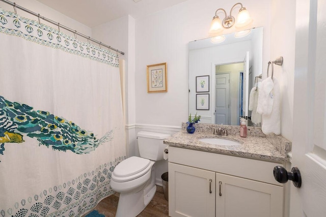 bathroom featuring toilet, a shower with shower curtain, and vanity