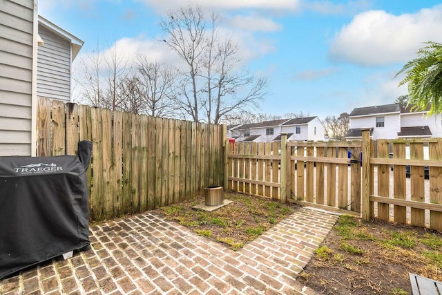 view of yard with a residential view, a fenced backyard, and a patio