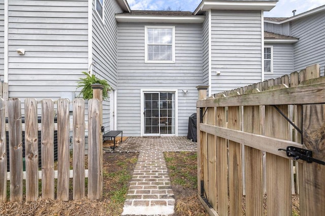 rear view of house featuring a patio and a fenced backyard