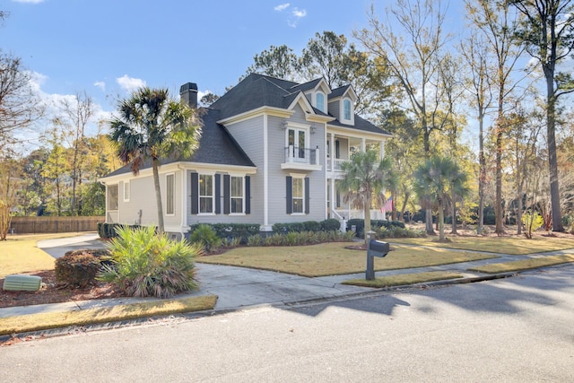 view of front of property featuring a front yard and a balcony