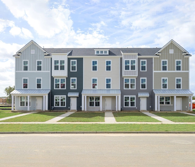 townhome / multi-family property featuring a front lawn