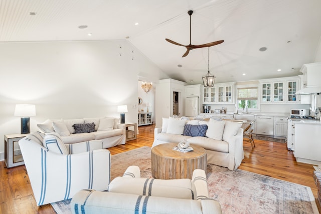 living room featuring light hardwood / wood-style flooring, a chandelier, and high vaulted ceiling