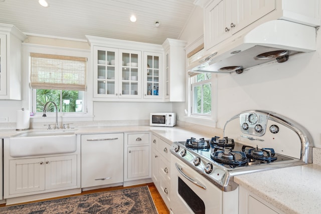 kitchen with white cabinets, lofted ceiling, sink, white appliances, and dark hardwood / wood-style floors