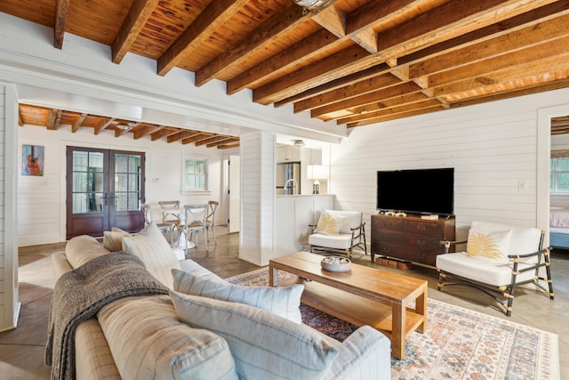 living room featuring wood ceiling, wooden walls, beamed ceiling, and french doors