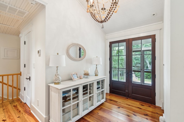 entryway featuring french doors, light hardwood / wood-style flooring, crown molding, and wood ceiling