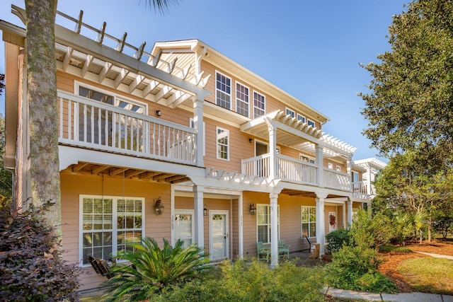 view of front of property featuring a balcony and a pergola