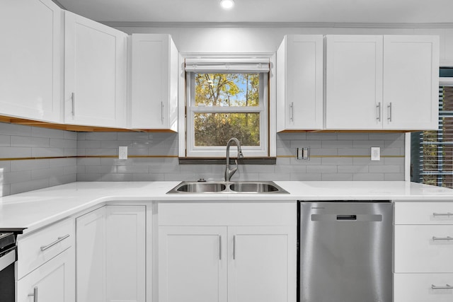 kitchen featuring stainless steel dishwasher, backsplash, white cabinetry, and sink