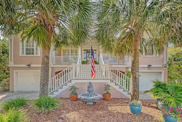 1308 Divot Ct, Mount Pleasant, SC 29466 - view of front of property featuring a garage, covered porch, stucco siding, stairway, and concrete driveway