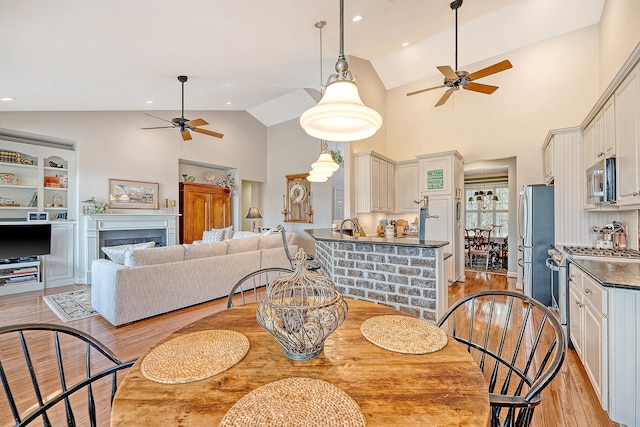 1308 Divot Ct, Mount Pleasant, SC 29466 - dining area with ceiling fan, light wood finished floors, high vaulted ceiling, and a fireplace