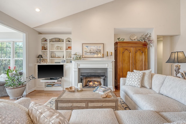 1308 Divot Ct, Mount Pleasant, SC 29466 - living area with lofted ceiling, light wood finished floors, built in shelves, a lit fireplace, and recessed lighting