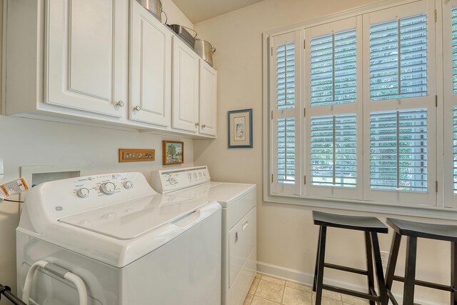 1308 Divot Ct, Mount Pleasant, SC 29466 - laundry area with washing machine and clothes dryer, baseboards, cabinet space, and light tile patterned floors
