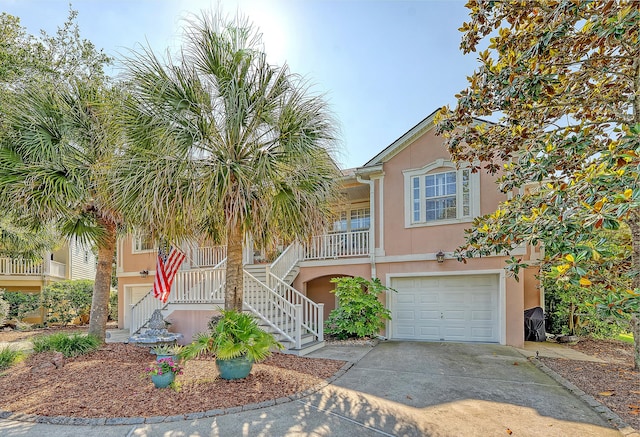 1308 Divot Ct, Mount Pleasant, SC 29466 - view of front of house featuring stucco siding, stairway, an attached garage, driveway, and a porch