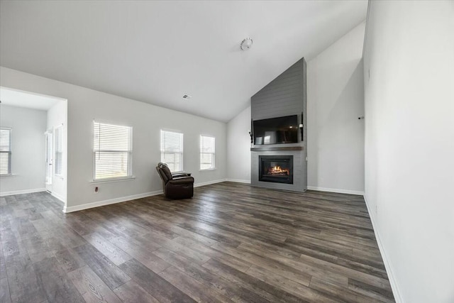 unfurnished living room featuring a fireplace, dark wood-type flooring, and vaulted ceiling