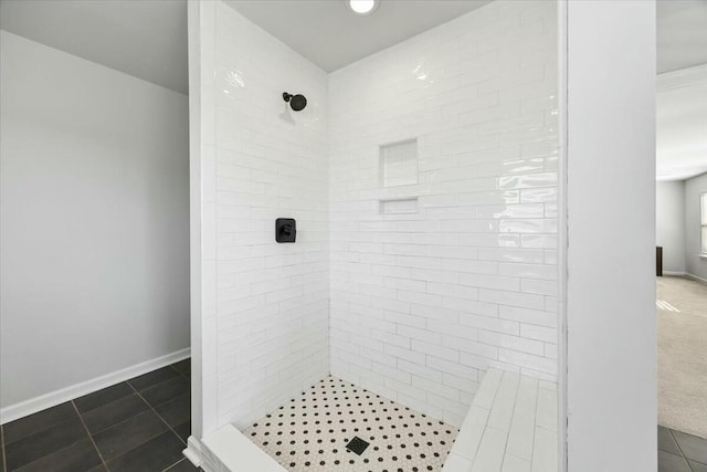 bathroom featuring tile patterned flooring and a tile shower