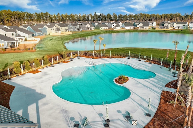 view of swimming pool with a yard and a water view