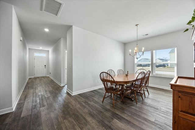 dining area with dark hardwood / wood-style floors and a notable chandelier