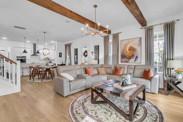 living room featuring a notable chandelier, light hardwood / wood-style floors, and beam ceiling