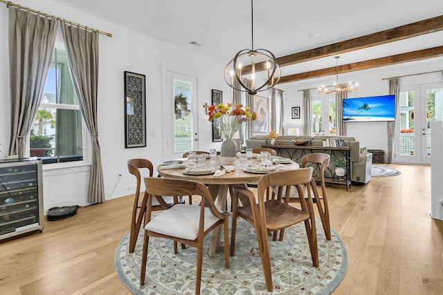 dining space with an inviting chandelier, light hardwood / wood-style floors, and a wealth of natural light