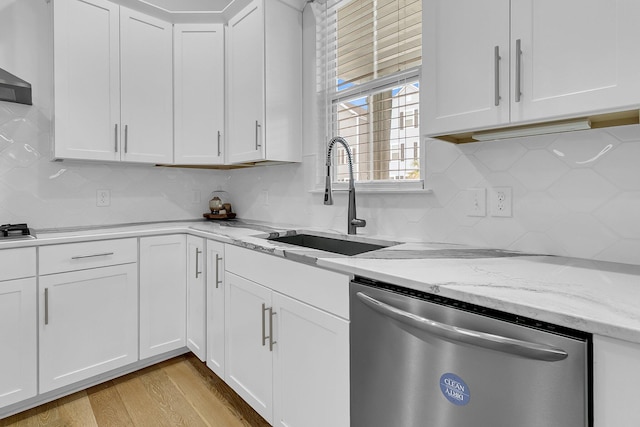 kitchen featuring light stone counters, light hardwood / wood-style floors, sink, white cabinetry, and stainless steel dishwasher