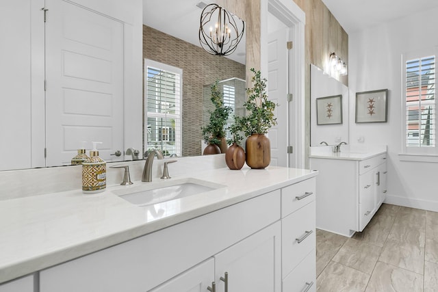 bathroom featuring a shower with door and vanity