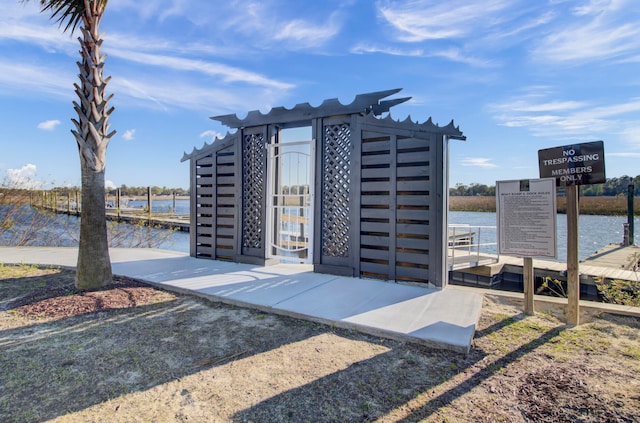 view of property's community featuring a pergola, a water view, and a dock