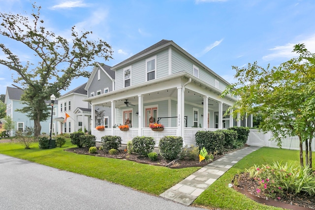 view of front of home with ceiling fan, a front yard, and a porch