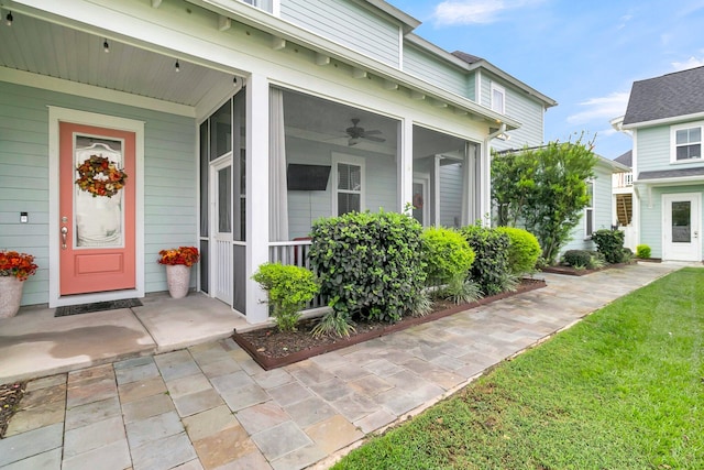 doorway to property featuring a lawn and ceiling fan