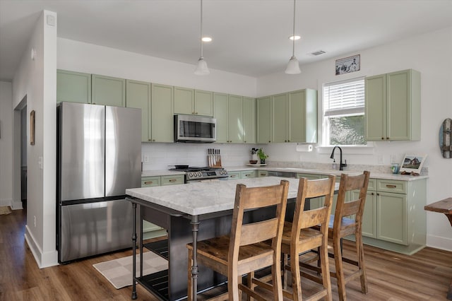 kitchen featuring pendant lighting, backsplash, stainless steel appliances, light stone counters, and dark hardwood / wood-style flooring