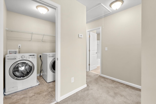 laundry room with washing machine and clothes dryer and light carpet