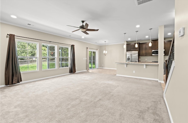 unfurnished living room featuring crown molding, ceiling fan with notable chandelier, and light carpet