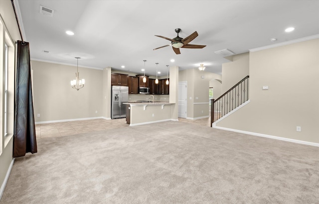 unfurnished living room with crown molding, light carpet, and ceiling fan with notable chandelier