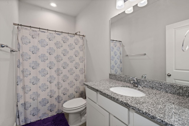 bathroom with toilet, vanity, and a shower with curtain