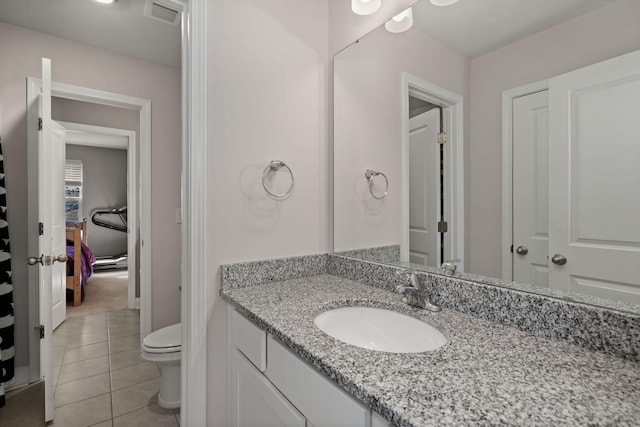 bathroom featuring toilet, vanity, and tile patterned flooring