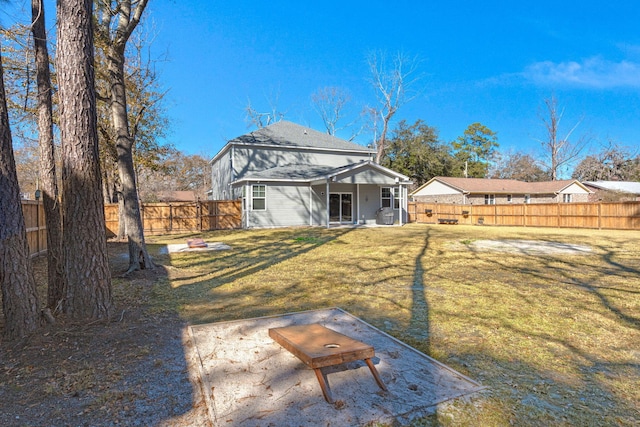 rear view of property featuring a patio and a yard