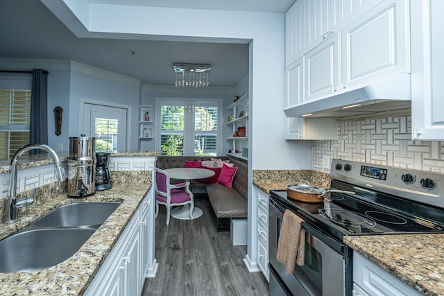 kitchen featuring electric stove, breakfast area, white cabinets, a sink, and under cabinet range hood