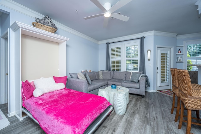 living area with dark wood-style floors, ornamental molding, and a ceiling fan