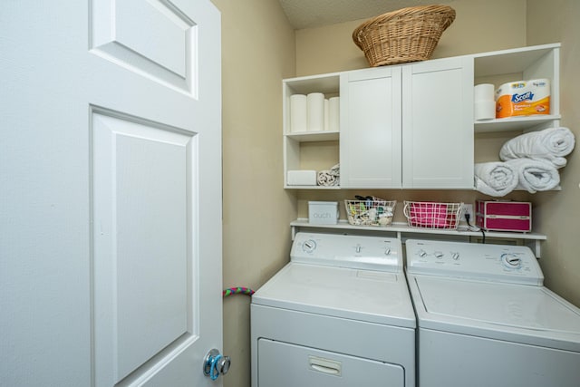 washroom featuring cabinet space and separate washer and dryer